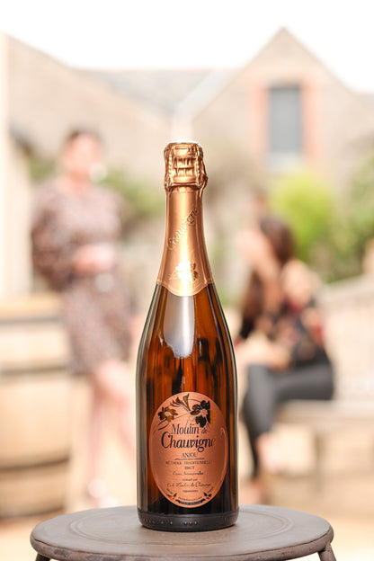 Bouteille de vin effervescent blanc brut Moulin de Chauvigné, AOP Anjou fines bulles, méthode traditionnelle, présentée en extérieur dans un cadre convivial au domaine en Vallée de la Loire